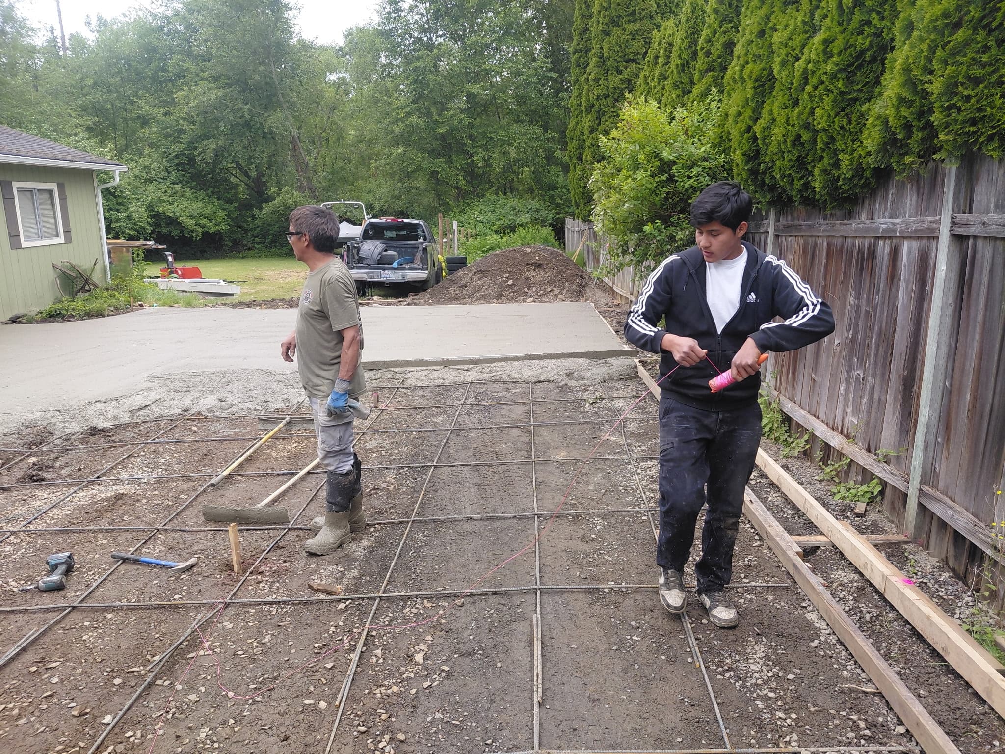 Construction crew laying rebar framework for residential foundation work