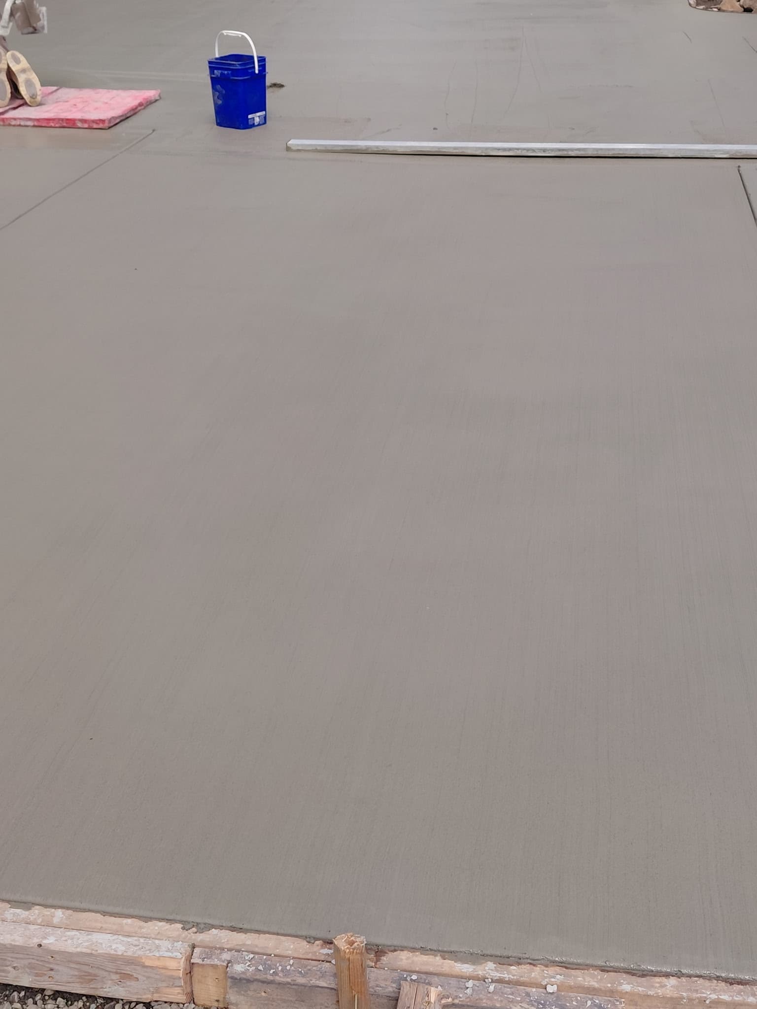 Large freshly poured and smoothed concrete slab with construction forms
