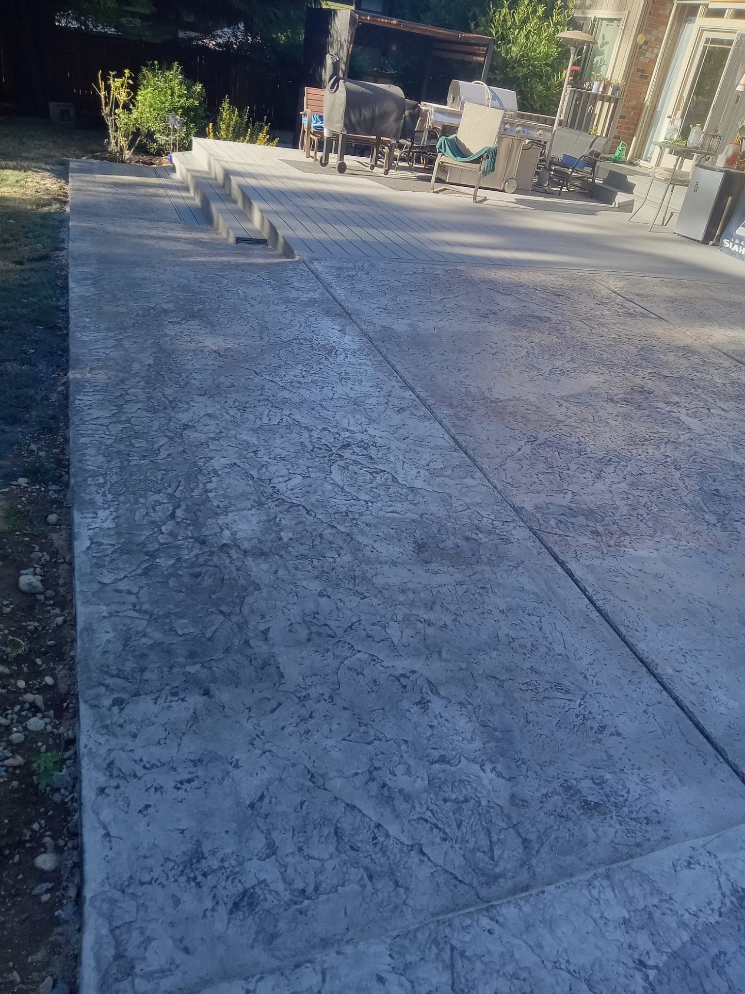 Stamped concrete patio with steps leading to outdoor living area