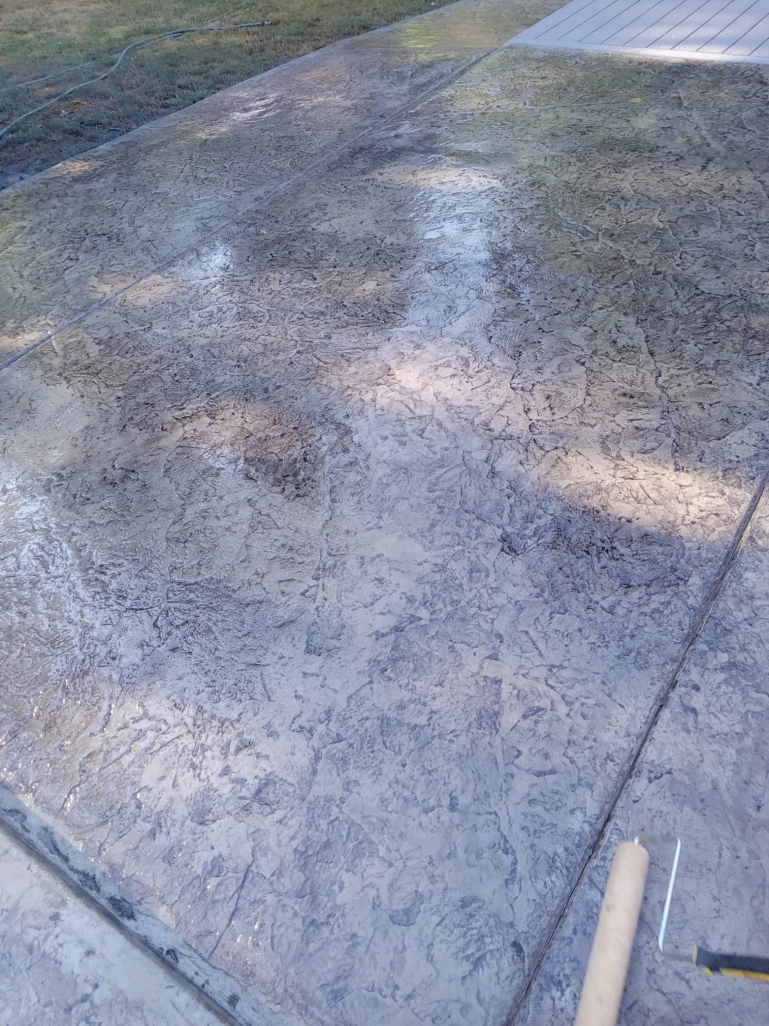 Close-up of dark stamped concrete with stone-look texture pattern